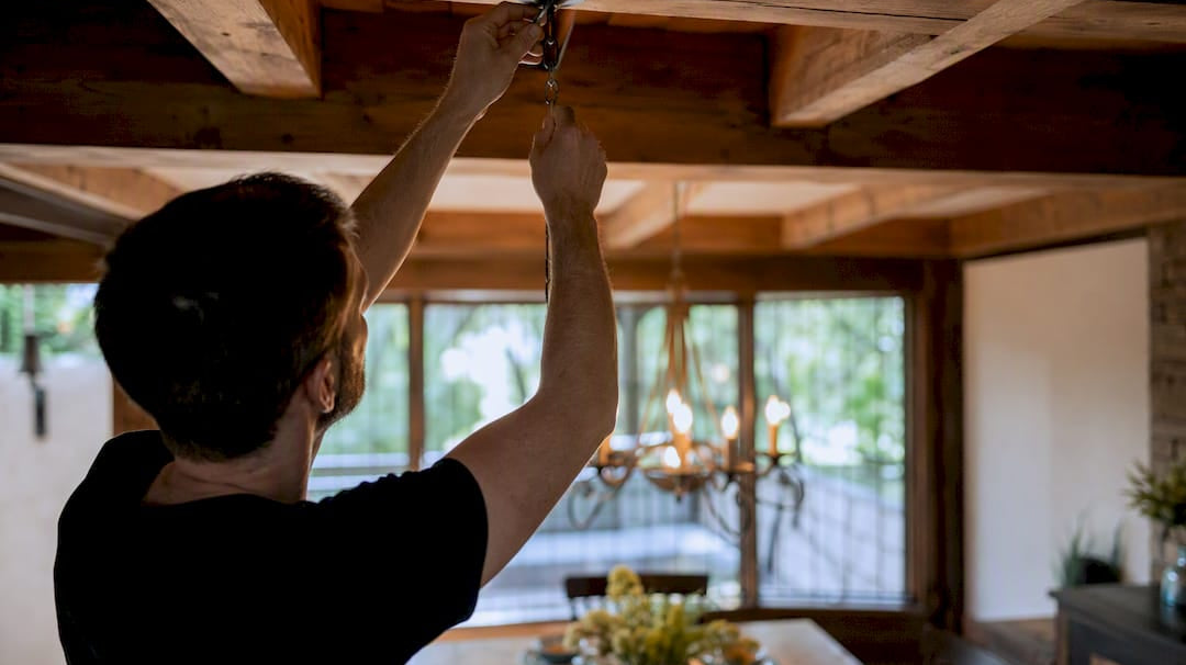 Hands adjusting chandelier swag hook