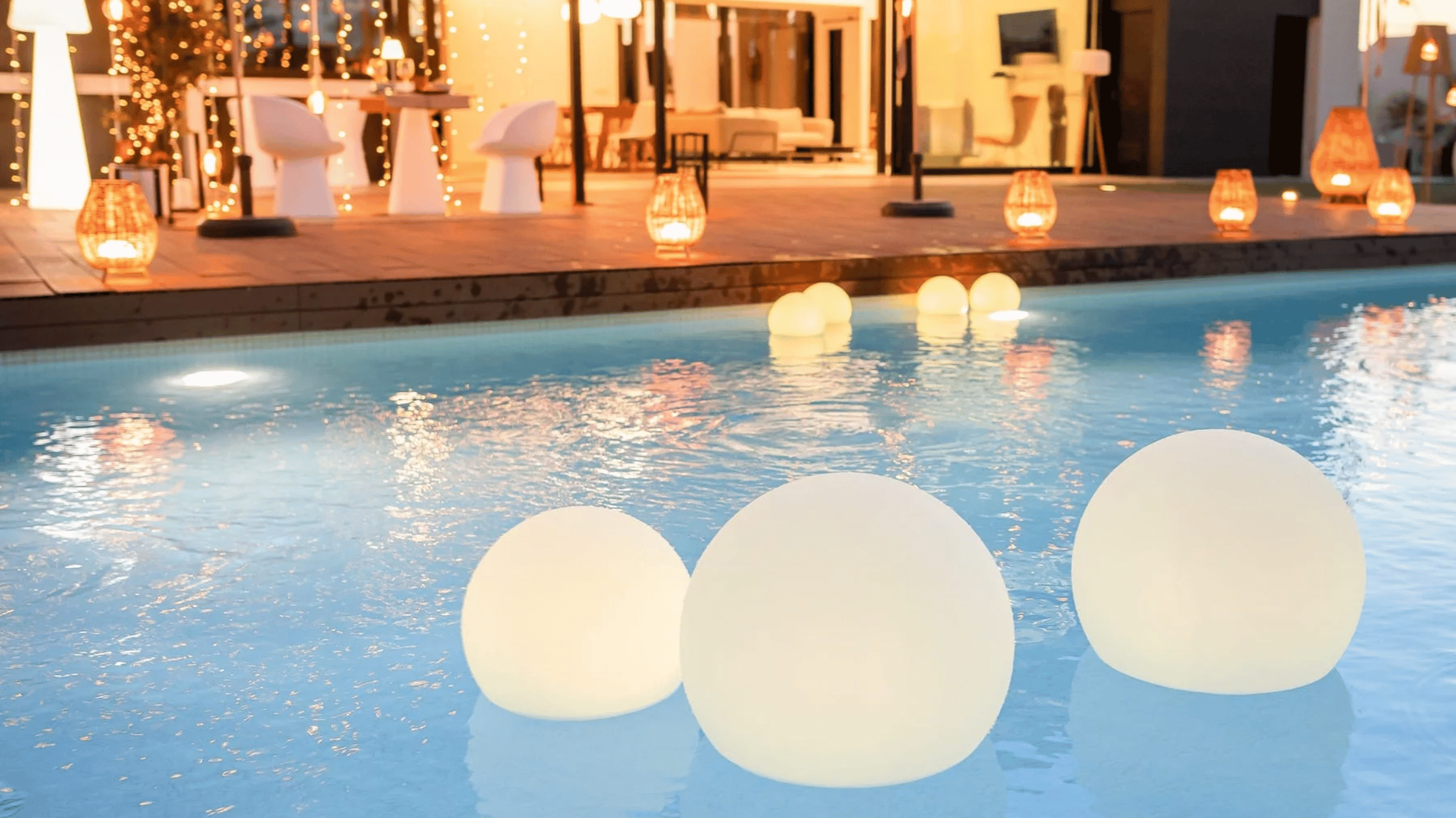 portable lights floating in a pool in a backyard