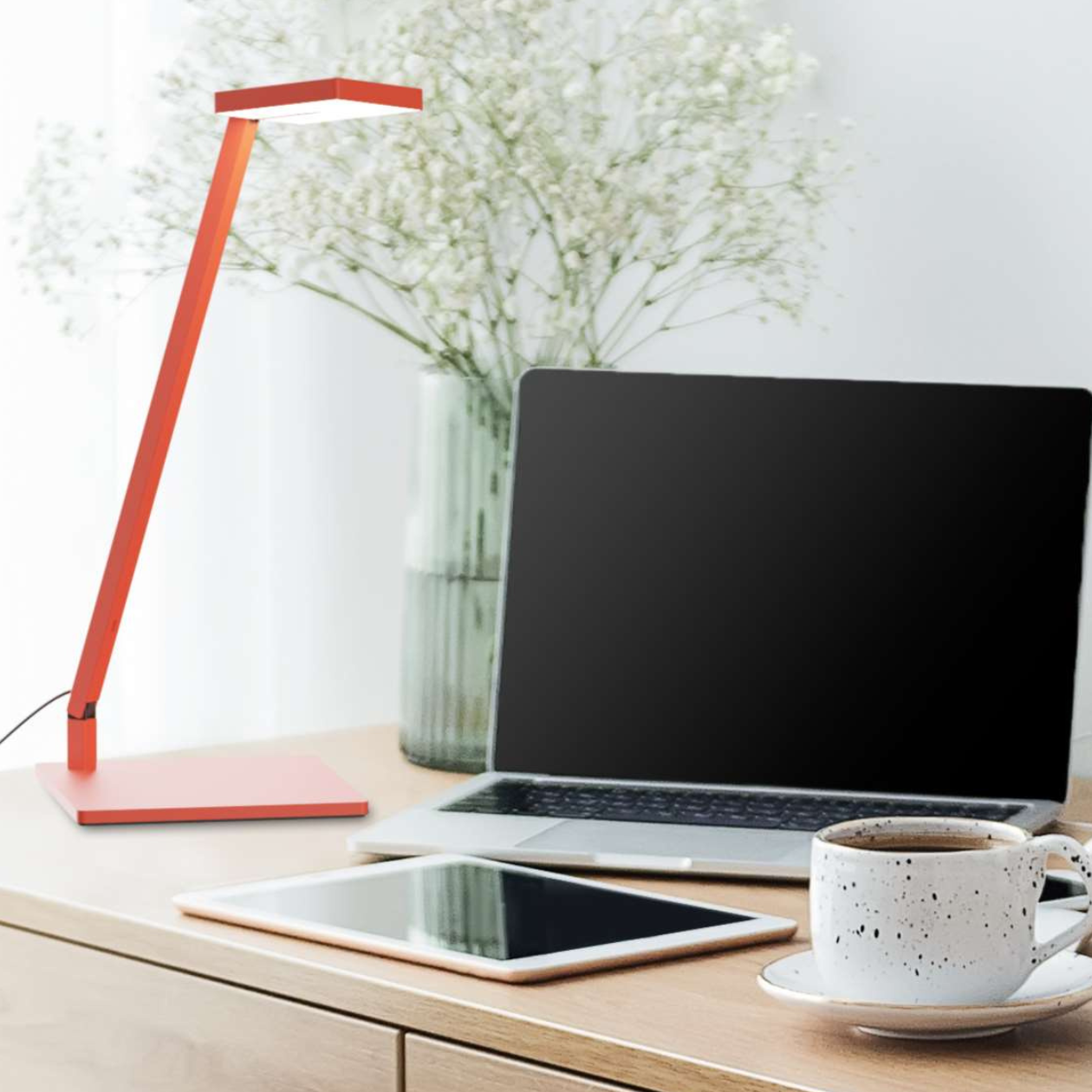 a desk with a lamp for task lighting to illuminate a laptop and ipad