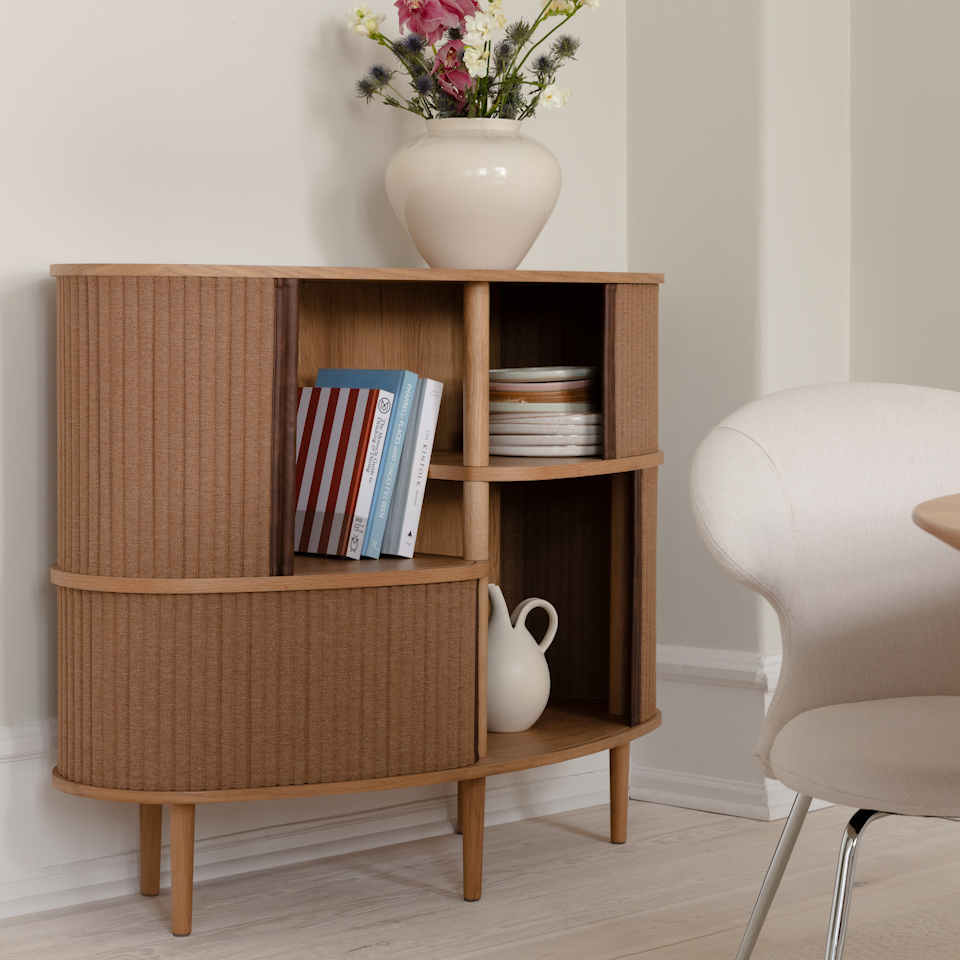 Table haute Umage Audacious en chêne avec portes Sugar Brown, disposée dans une pièce
