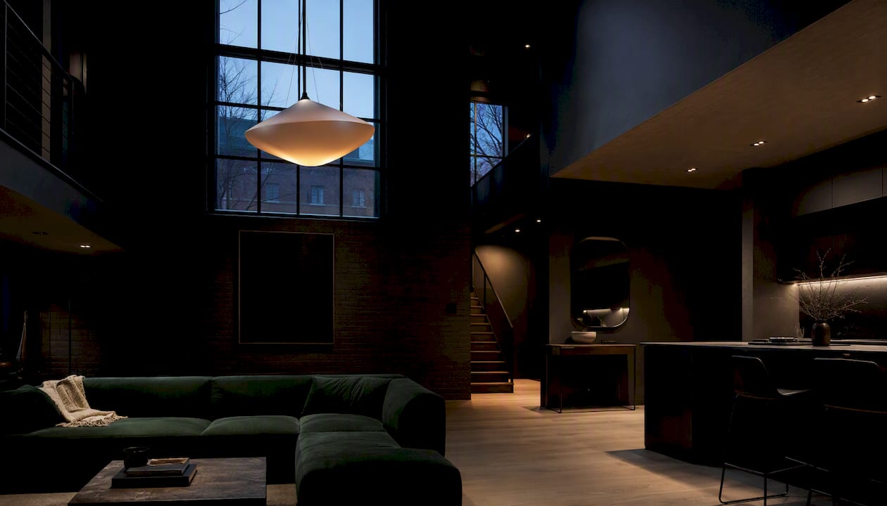 Large chandelier and recessed lights in tall living room