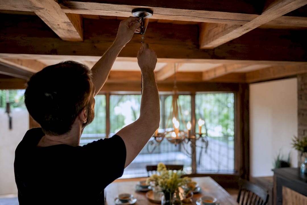 Hands adjusting chandelier swag hook