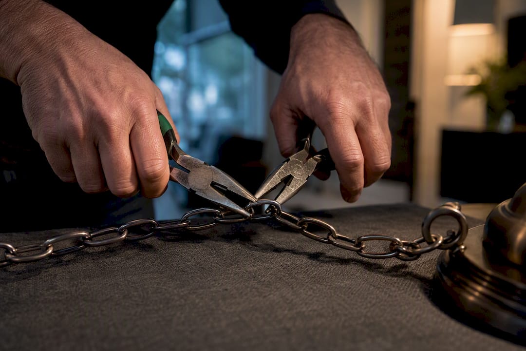 Hands shortening an anonymous chandelier chain