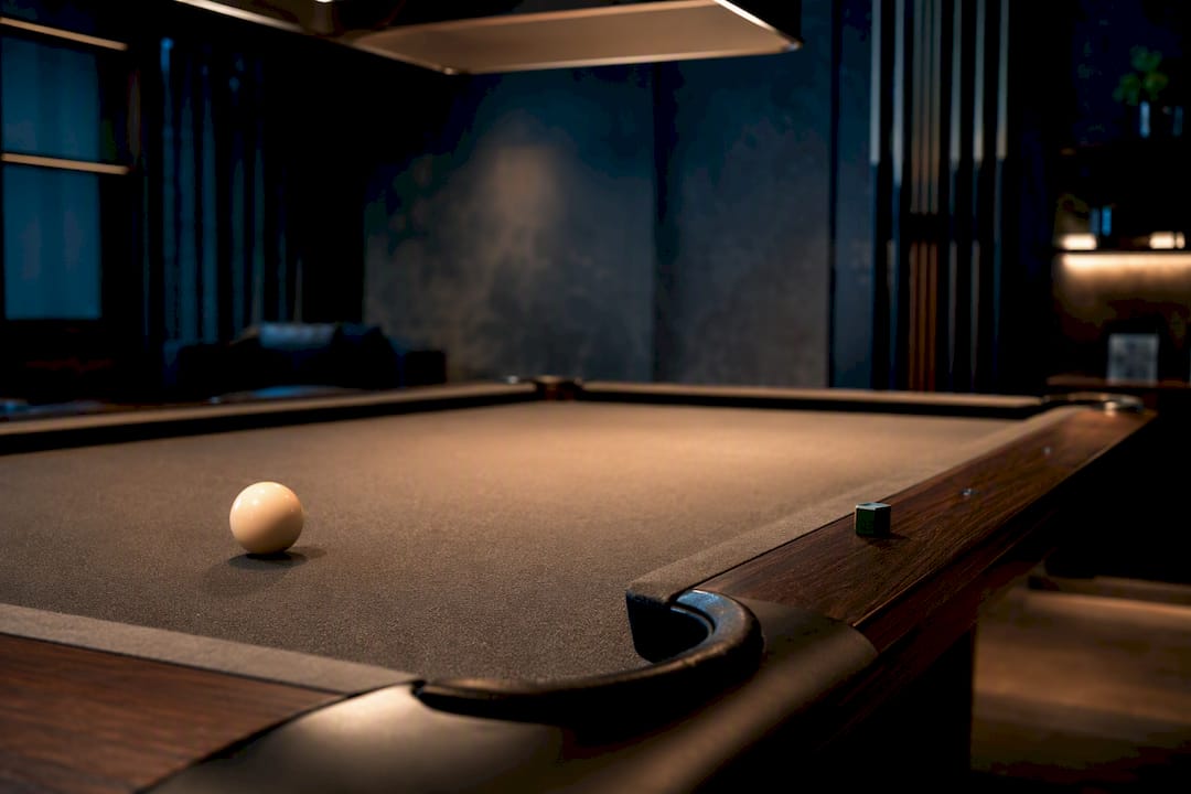 Billiard table beneath carefully positioned overhead light