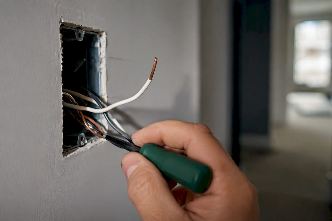 Electrician checking neutral wire in switch box