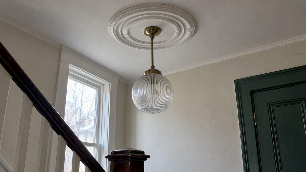 Ribbed glass pendant beneath a ceiling medallion