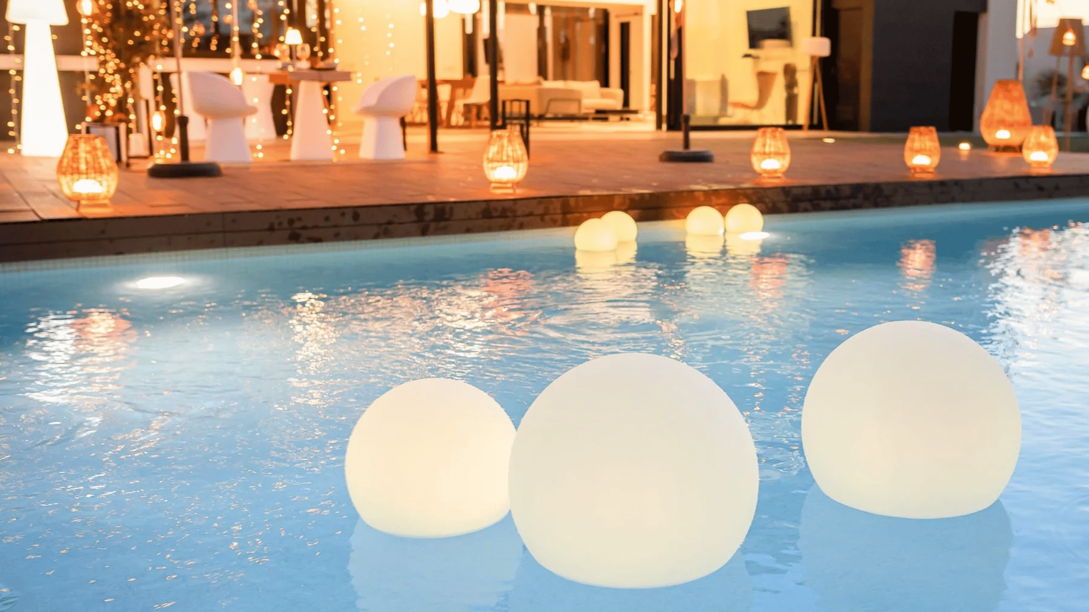 portable lights floating in a pool in a backyard