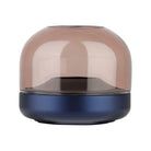 Glow 08 candle holder with amber glass dome atop a navy blue base.