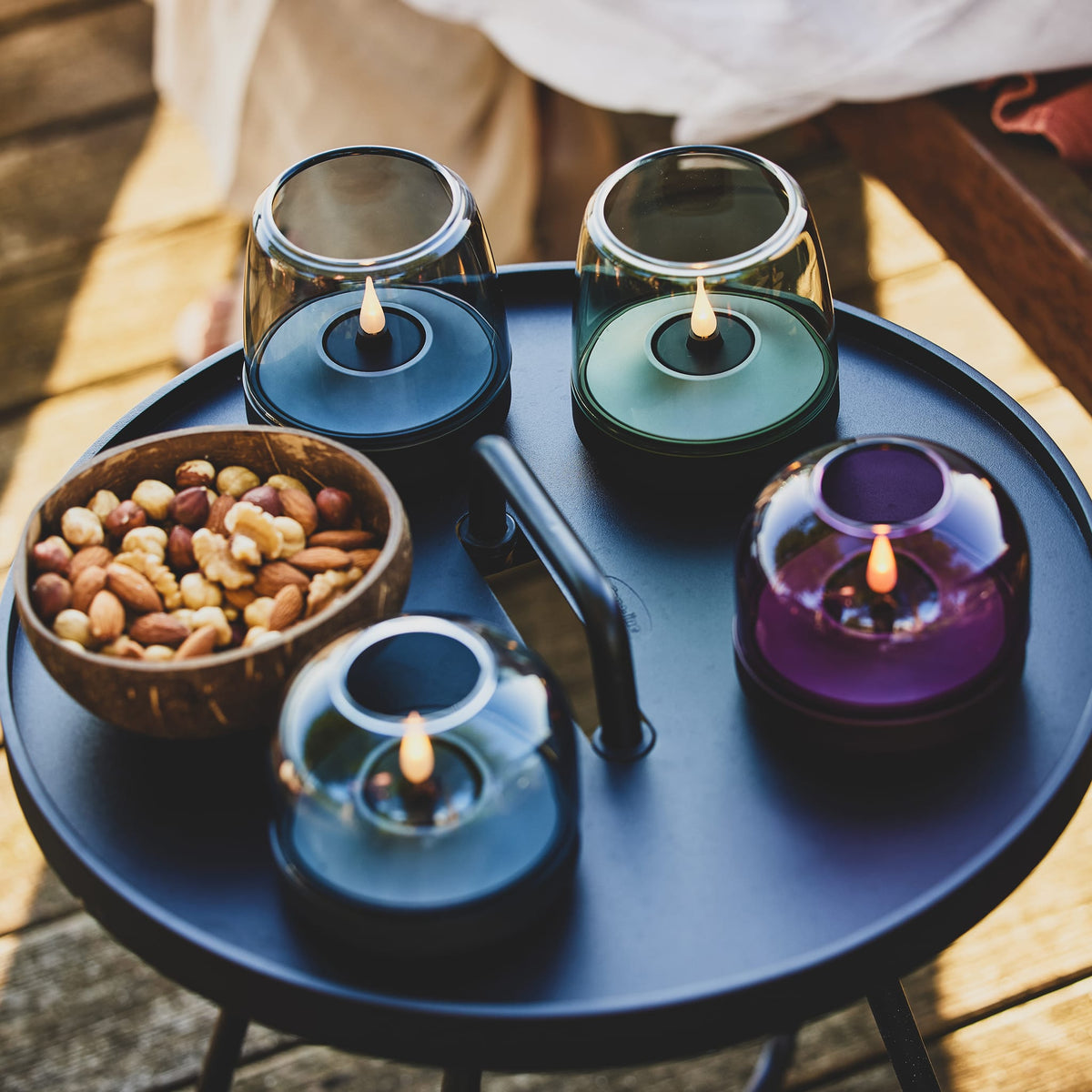 Glow 08 candle holder set with colorful glass domes and LED flames on a round tray.