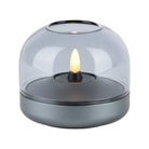 Glow 08 candle holder with gray base and clear glass dome housing a warm LED flame.