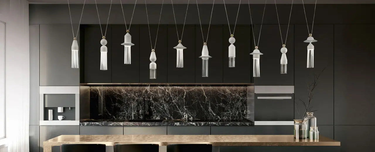 Modern kitchen with black marble backsplash, pendant lights, and black chairs.