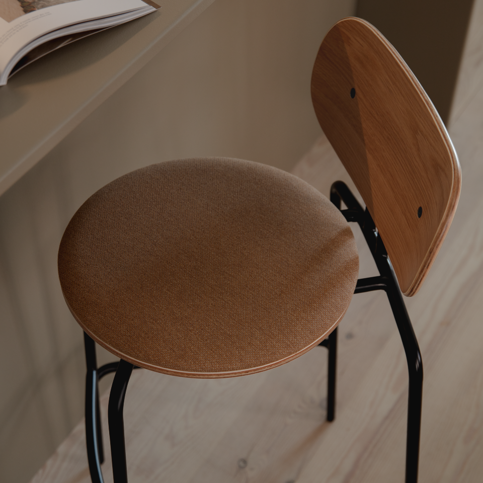 Umage Curious Bar Stool in oak with black legs and Sugar Brown cushion, styled at a counter